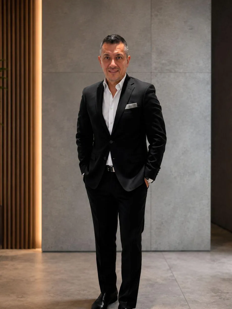 Andrés Arteaga, de pie, con traje oscuro